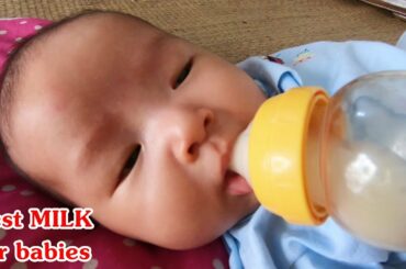 Cute baby Boy drinking milk from a bottle - Breast Milk is best for Baby