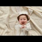 Cute baby smiling and looking in the camera close up. Little kid in Easter bunny costume, top view