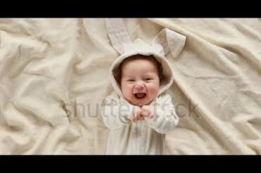 Cute baby smiling and looking in the camera close up. Little kid in Easter bunny costume, top view