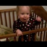 Cute baby throwing her bunny out of the crib over and over