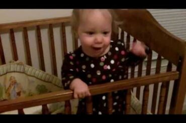 Cute baby throwing her bunny out of the crib over and over