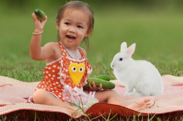 cute baby girl and mom give Cucumber to Rabbit , cute baby girl fed Cucumber to Rabbit