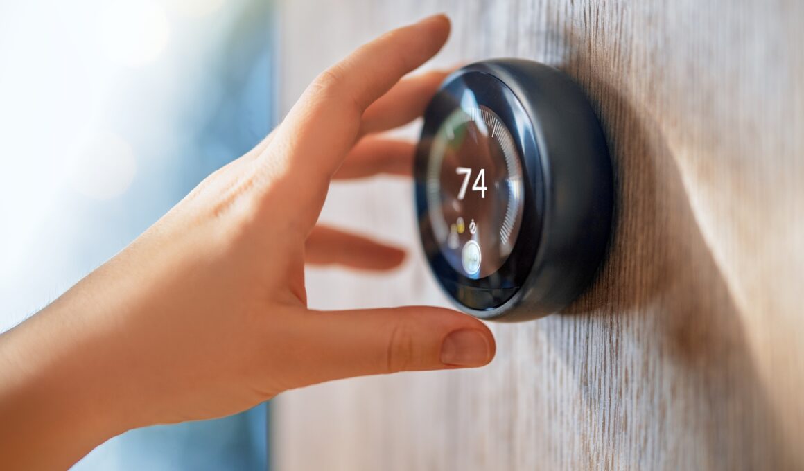 A hand adjusts a digital thermostat displaying a temperature of 74 degrees.